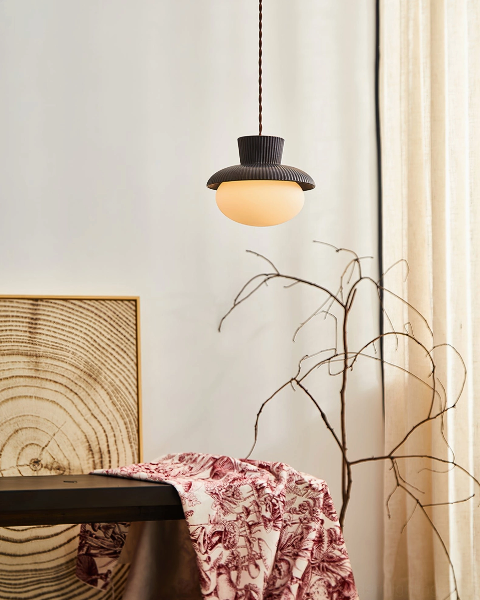 Kaskad pendant lamp installed in modern home interior, wide side perspective showing fixture above table with ambient warm lighting effect