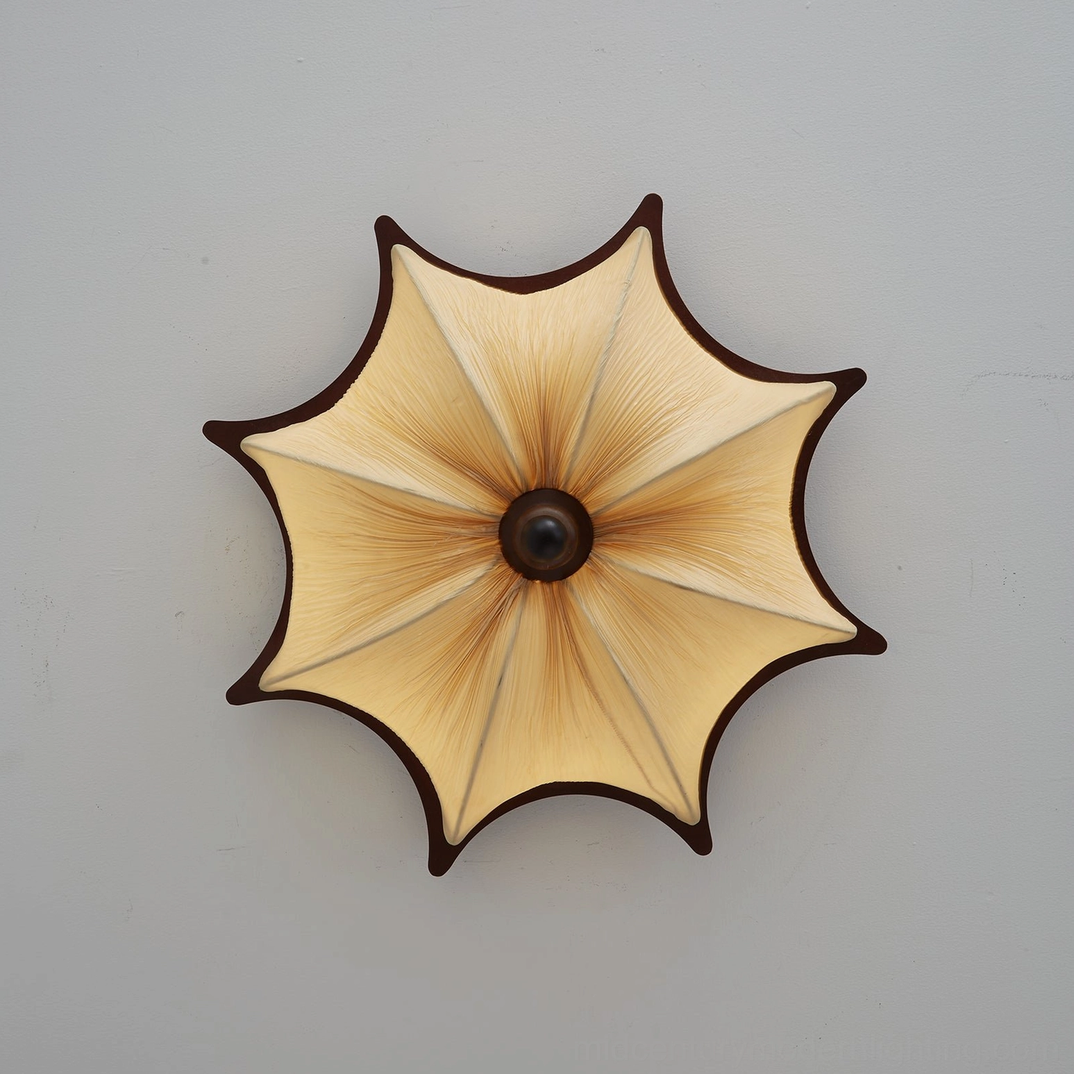 Kateo fabric ceiling light glowing softly, demonstrating gentle diffused ambient lighting and sculptural form