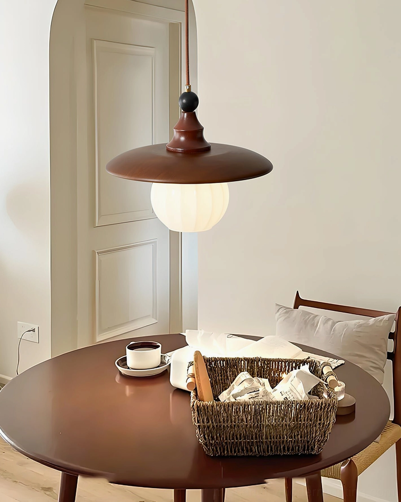 Kato single vintage pendant light above round wooden dining table, cozy warm decor
