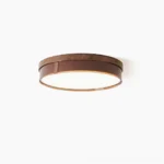 Kelsey round flush mount ceiling light with walnut wood-grain trim, overhead studio view showing minimalist mid-century modern design