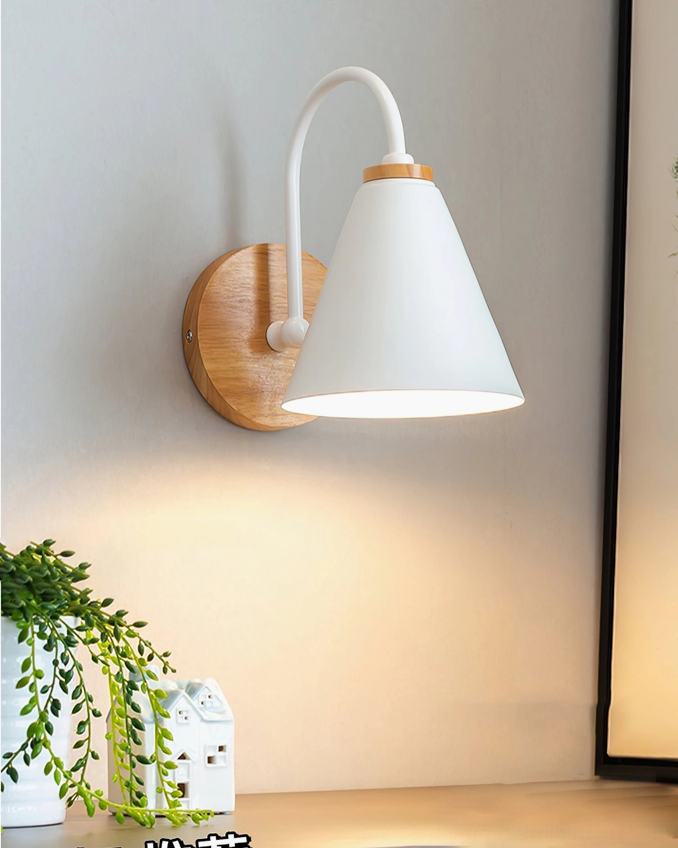 Kenji wall lamp illuminated by desk with small decorative items showing warm glowing light and modern form