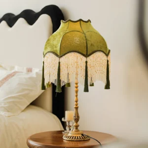 Vintage Kennedy table lamp with olive green velvet shade and dark green tassel trim in bedroom bedside setting