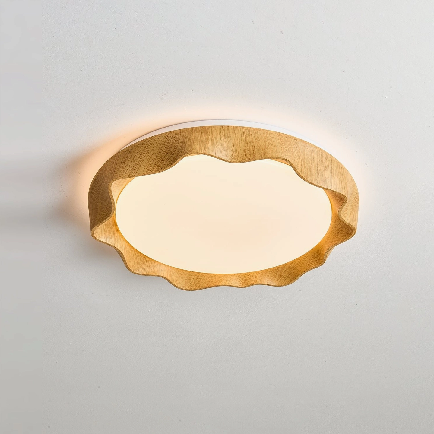 Kerio light wood tone ceiling light with wavy scalloped frame, illuminated close-up view