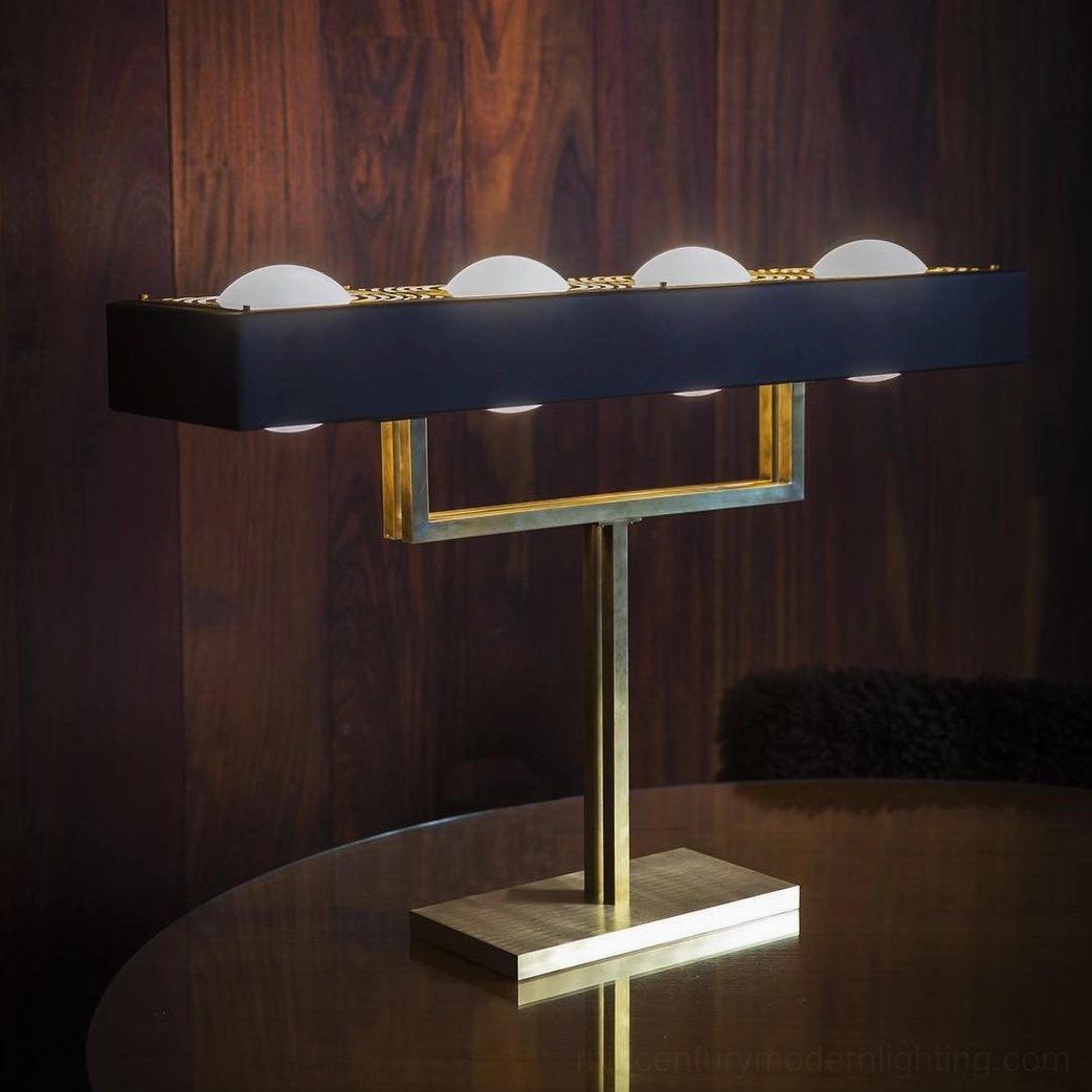 Four-bulb Kernel table lamp with long black shade and gold metal frame on dark wood side table