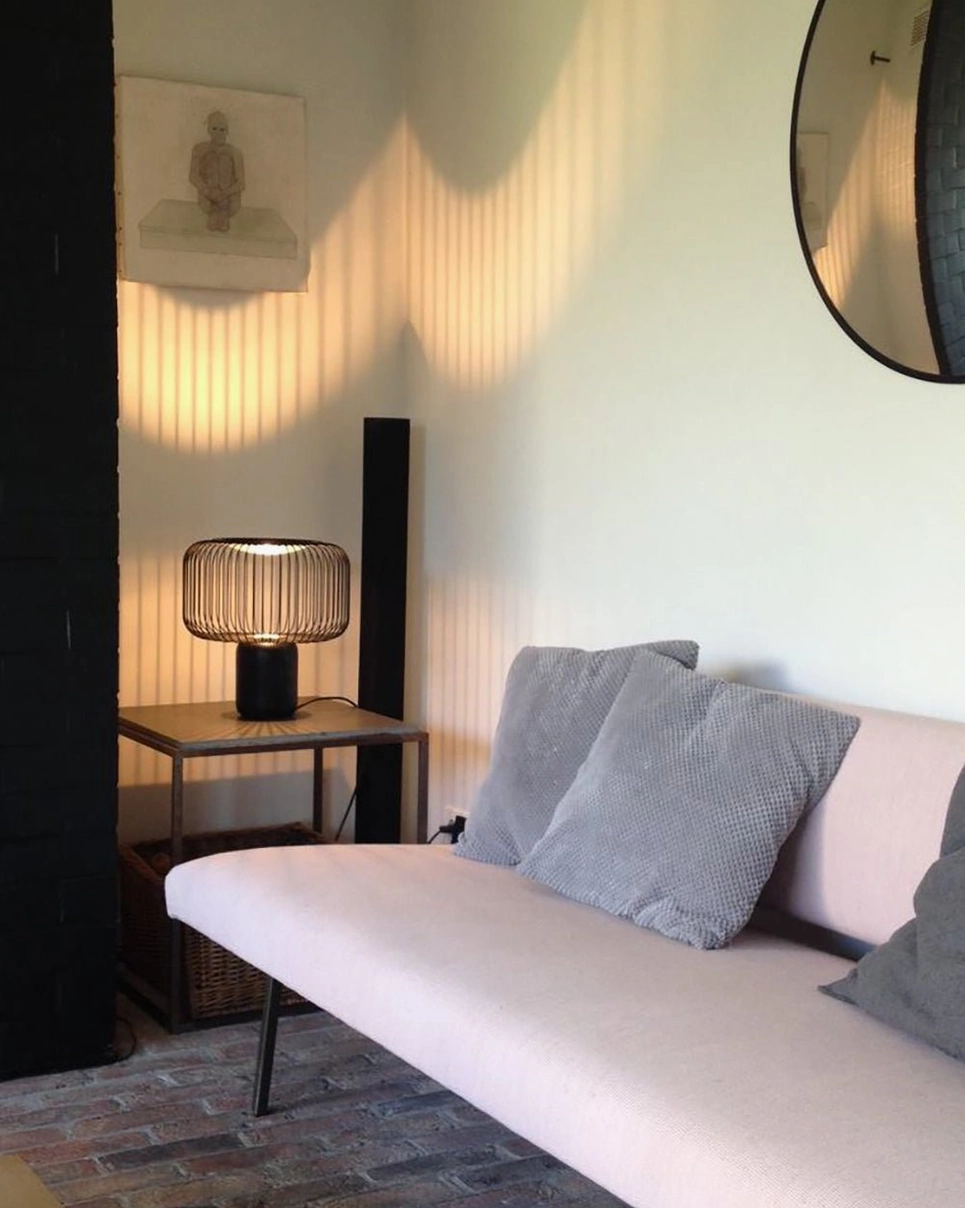 Keshi table lamp casting dramatic geometric shadows on interior wall surface