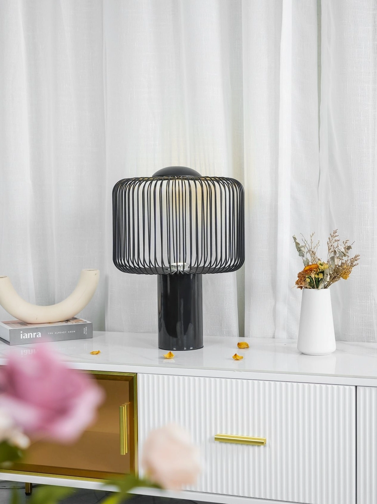 Keshi black marble table lamp three-quarter front with pink flower arrangement on console table