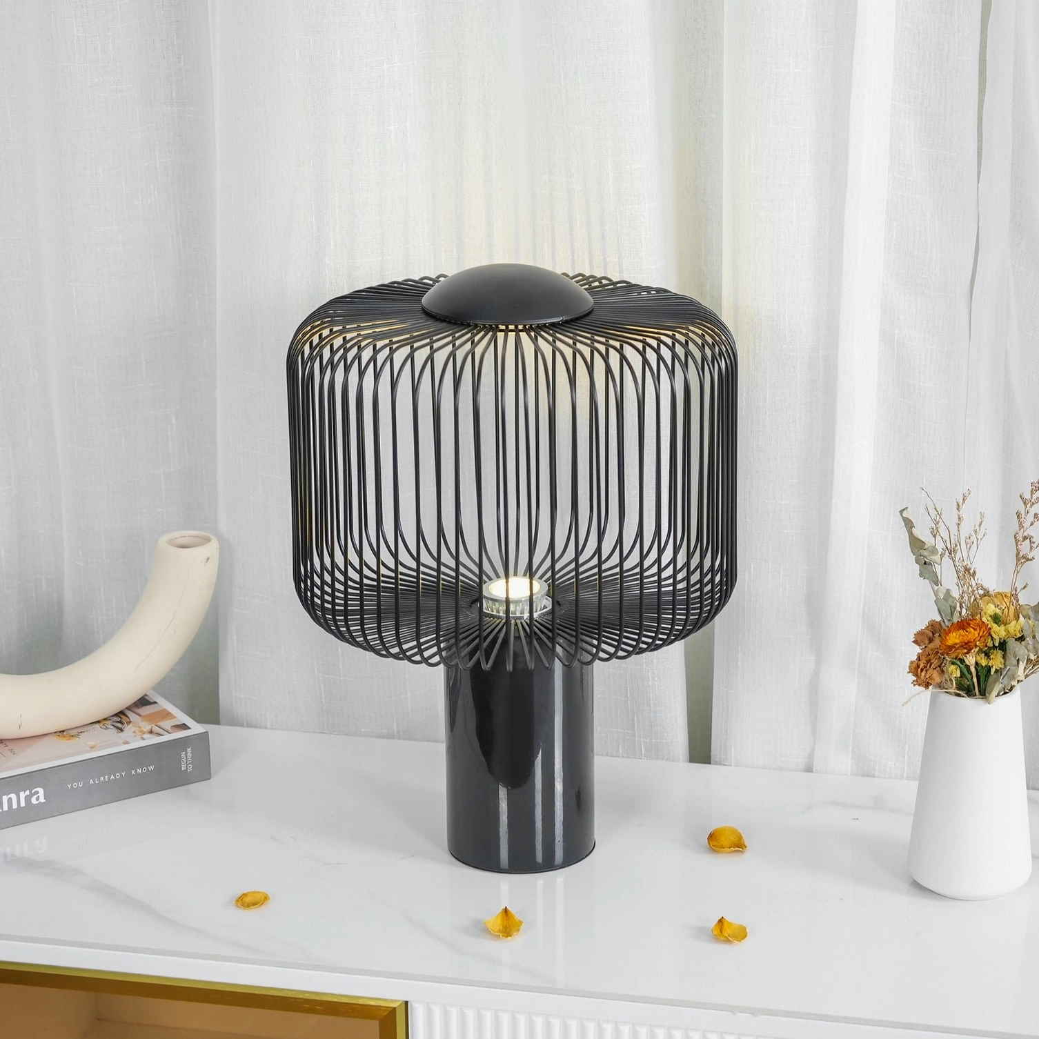 Keshi marble lamp side three-quarter view on console table with curtain backdrop showing cylindrical marble base