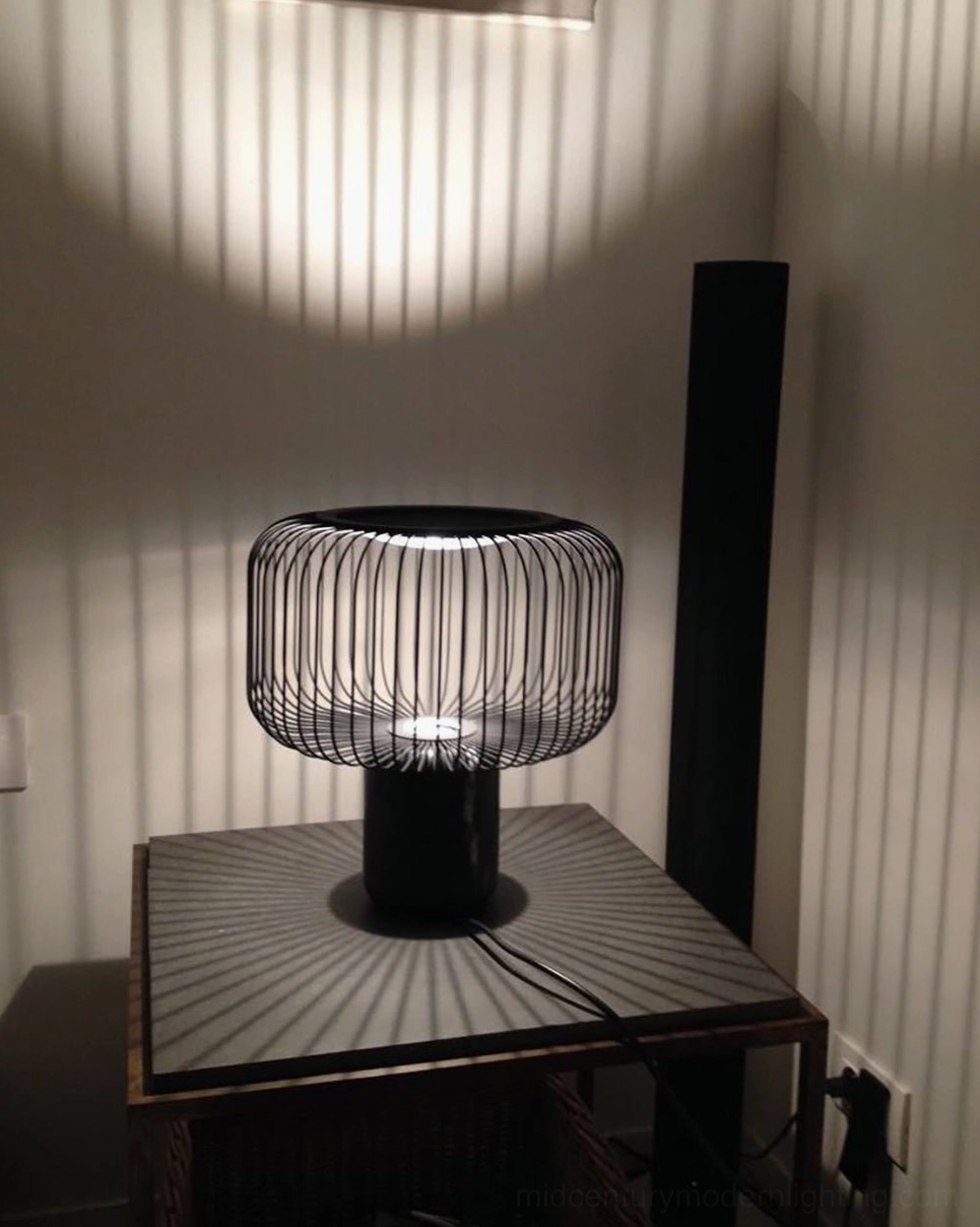 Keshi table lamp side view creating geometric shadow pattern on white wall at night