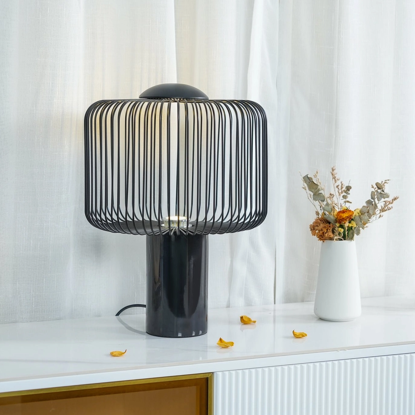 Keshi table lamp front flat view on console with sheer curtain showing warm internal LED glow