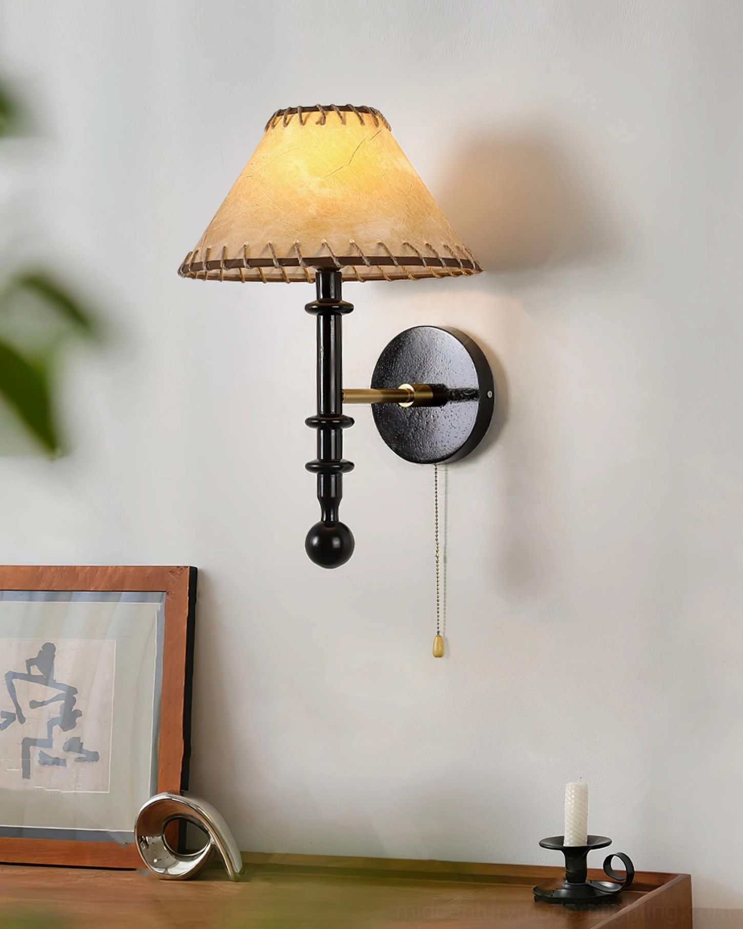 Kibo mid-century modern wall sconce mounted in home office corner with desk styling and artwork backdrop