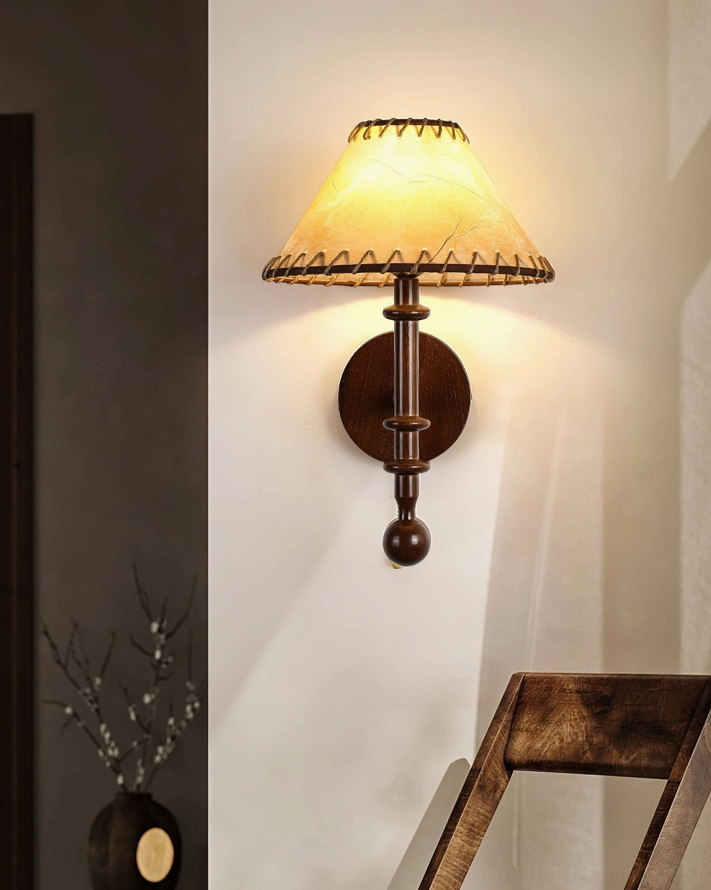 Kibo wood wall lamp with dark brown wooden pole and round metal base in home interior corner with wooden chair