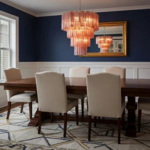 Pink tiered glass tube chandelier hung in formal dining room with dark blue accent wall elegant lighting