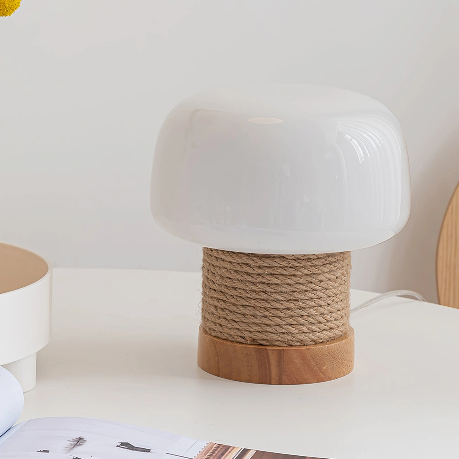 Scandinavian mushroom lamp on white desk with books and artwork