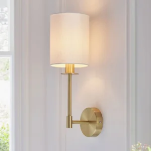 Kington wall sconce mounted in sunlit hallway with polished brass hardware and soft linen diffuser