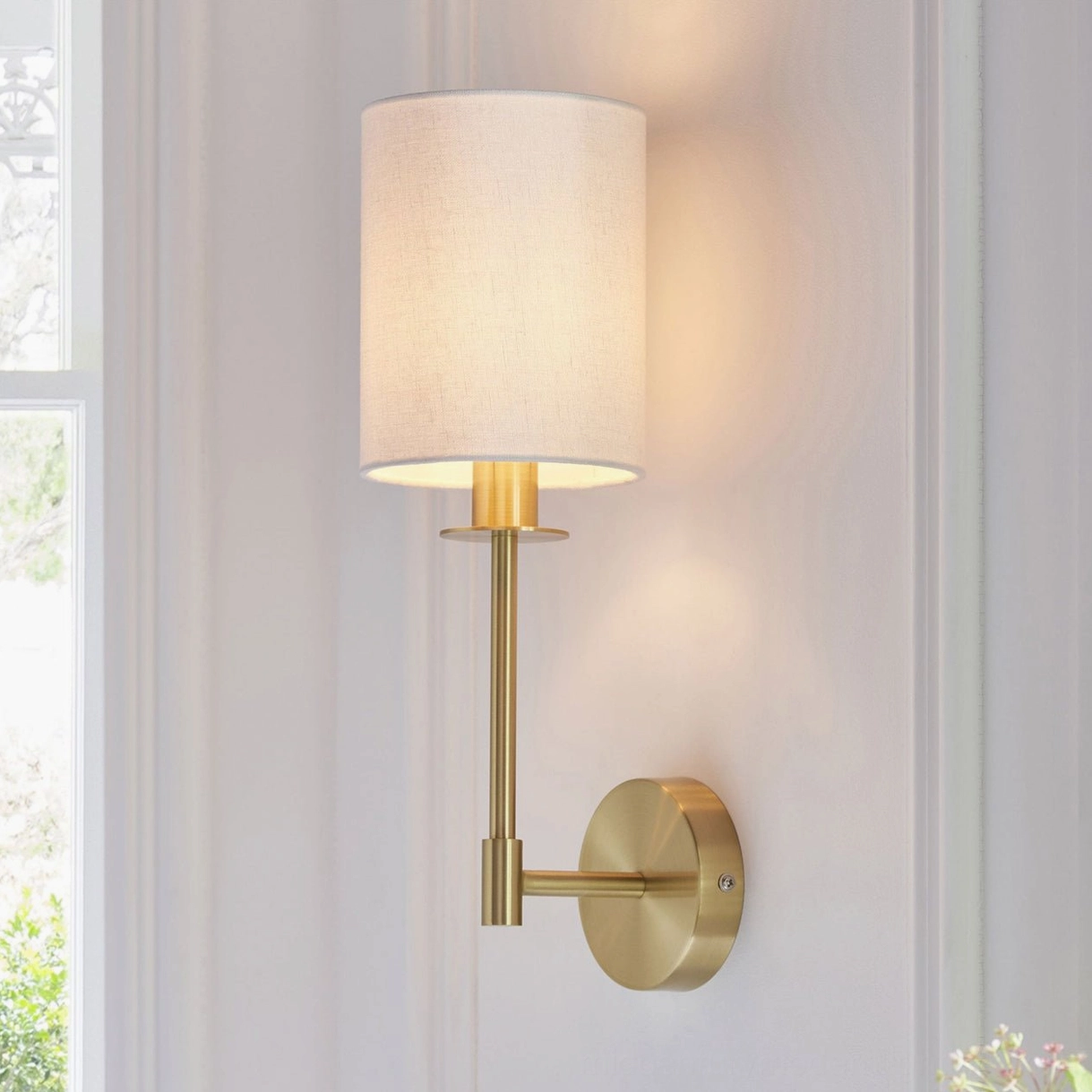 Kington wall sconce mounted in sunlit hallway with polished brass hardware and soft linen diffuser