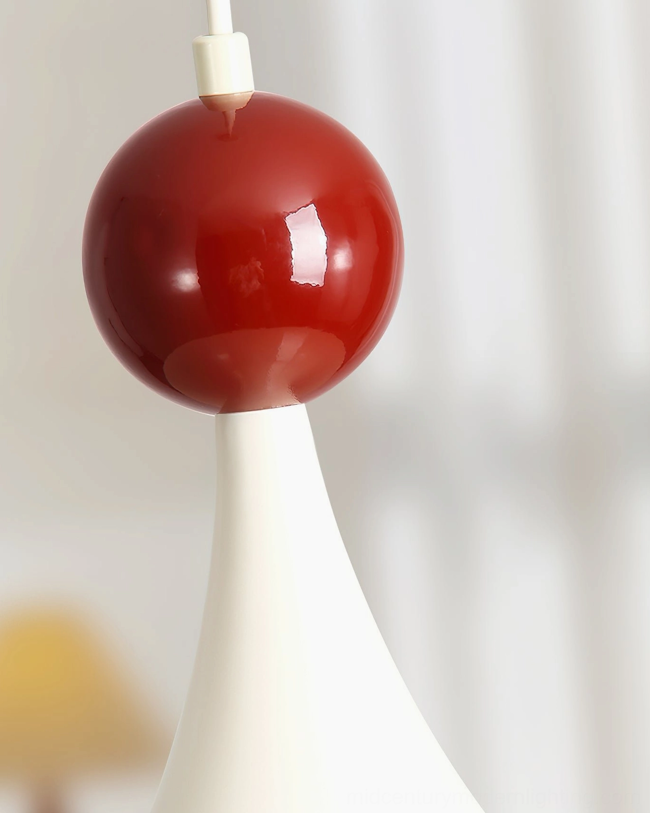 Macro close-up of Kinvara pendant light's glossy burgundy red spherical accent detail