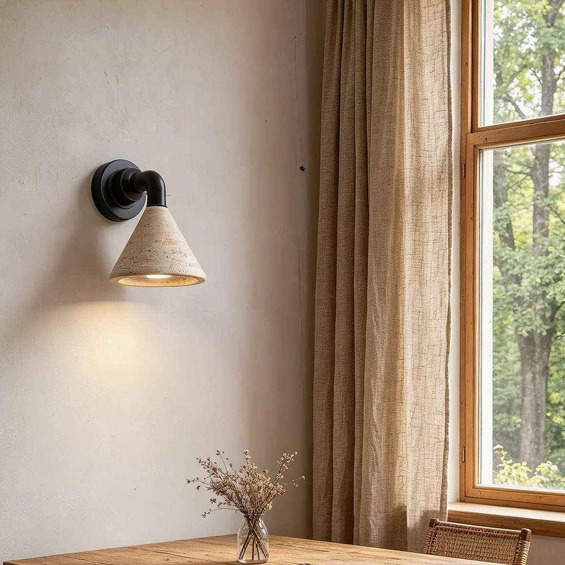 Kiran stone wall light illuminating warm neutral dining corner with wooden table and window light
