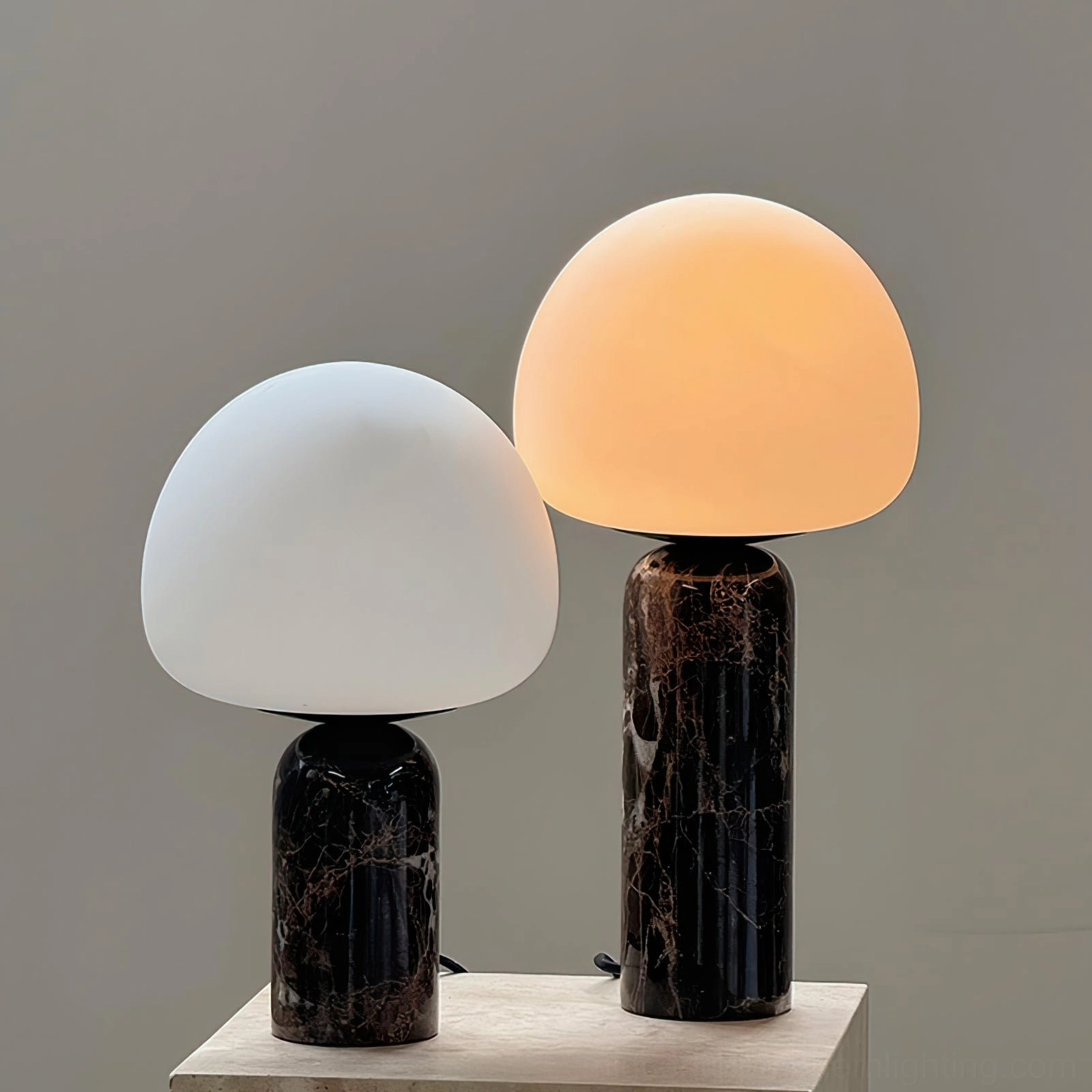 Pair of matching Kizu table lamps with different heights on wooden side table, one lit one unlit