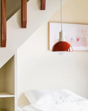 Kleine burgundy red dome pendant light illuminating modern attic bedroom – mid-century minimalist home decor with neutral styling