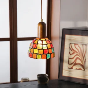 Klima pendant light casting warm colored light over vintage desk, three-quarter angle interior styling