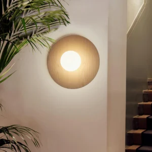 Knock wood color wall sconce mounted in modern japandi stairwell, warm ambient lighting in residential interior