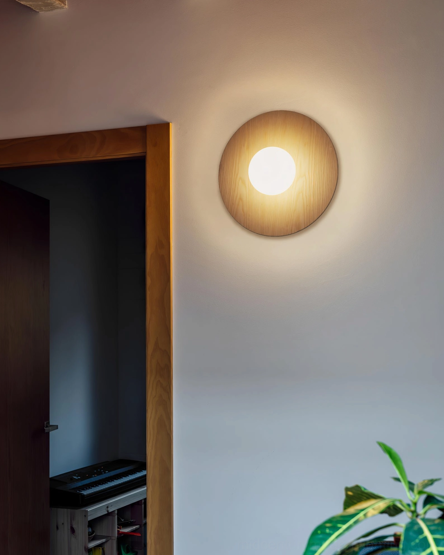Knock round wood grain wall lamp in modern entry corridor, compact sconce with warm neutral interior tone