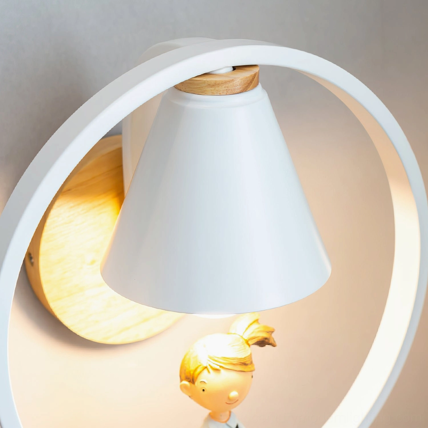 Close-up detail of Kona boy-themed wall sconce with white conical lampshade and wood grain natural wood base