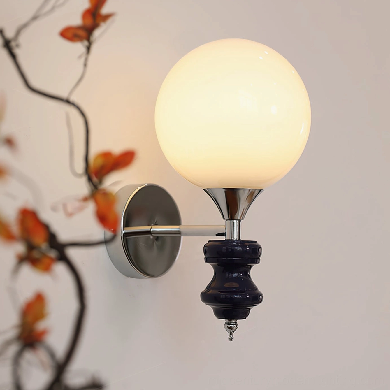 Koscina dark blue wall sconce illuminated - side wall close-up with dried floral styling and polished chrome mount