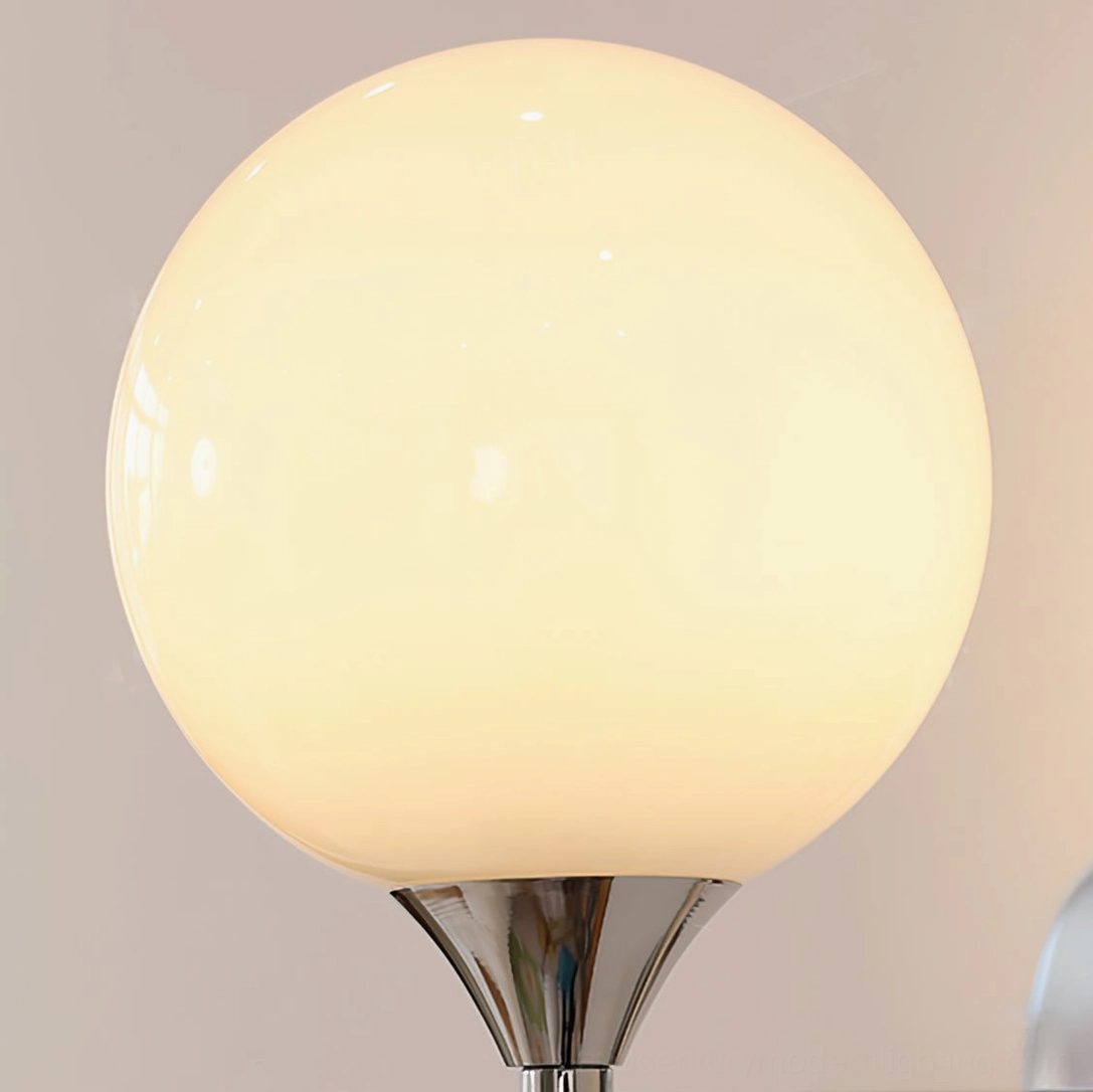 Koscina globe lampshade lit - warm yellow glowing light through frosted glass with chrome cap visible