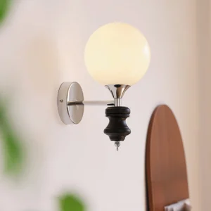 Koscina wall lamp illuminated in residential entryway - warm ambient light casting glow from chrome fixtures and frosted glass