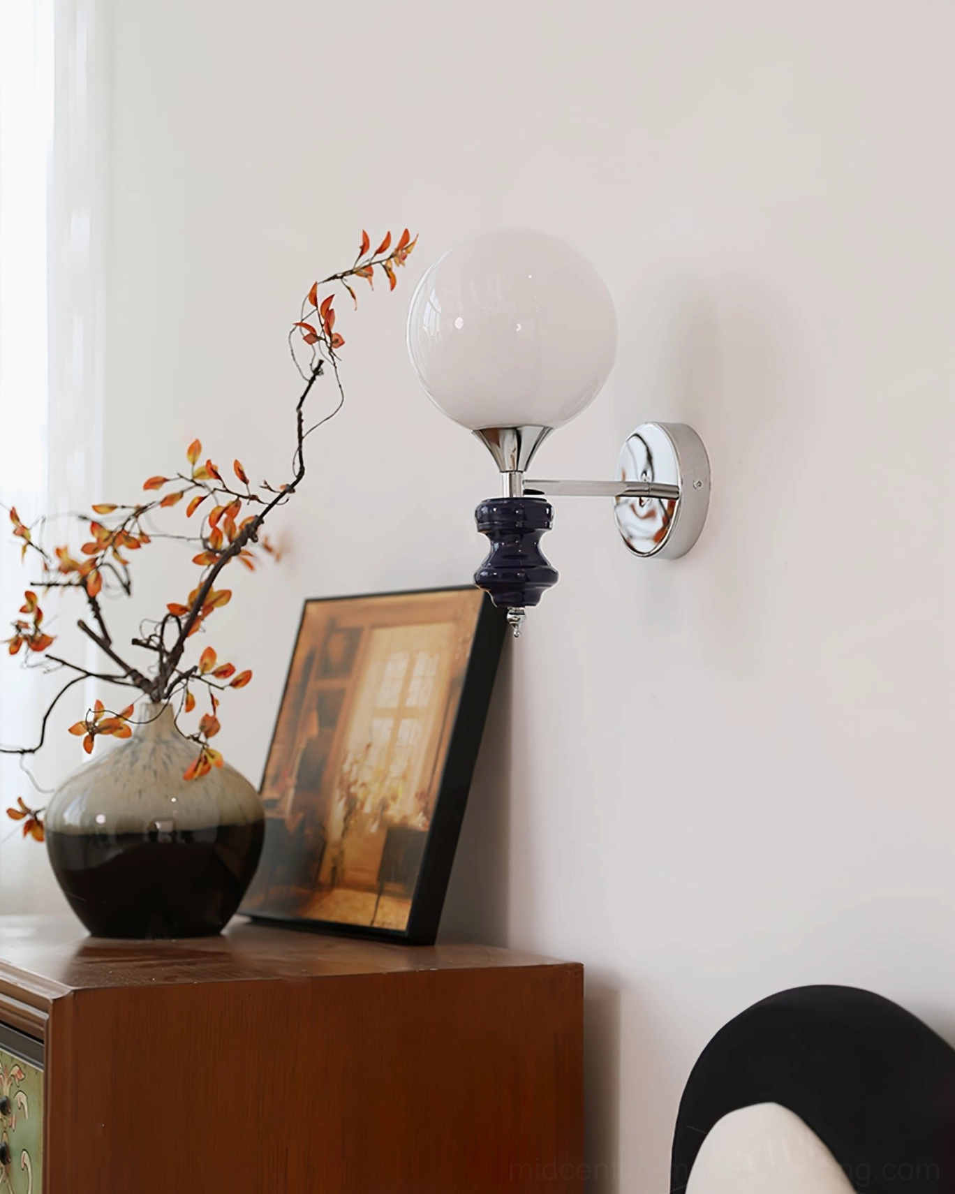 Koscina wall lamp in minimalist home setting - wide interior view with wood side table, decorative vase, and framed artwork