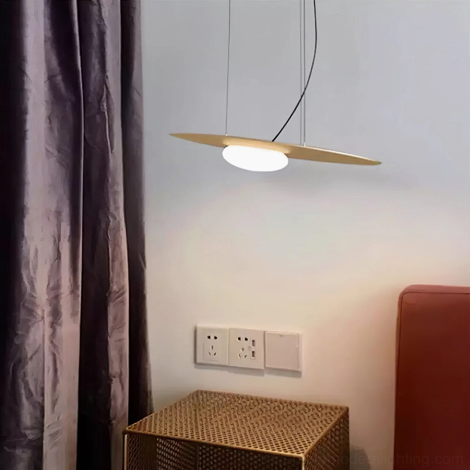 Brushed gold Kwic disc pendant light installed in modern residential interior with purple curtains, mid-century modern style