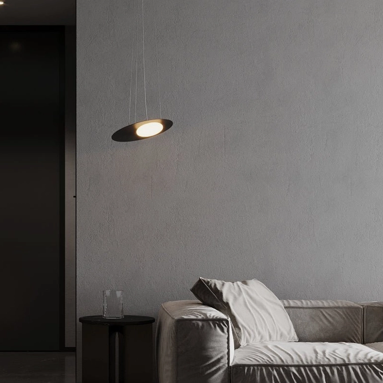 Small Kwic disc pendant lamp with matte black finish above gray fabric sofa in contemporary living room