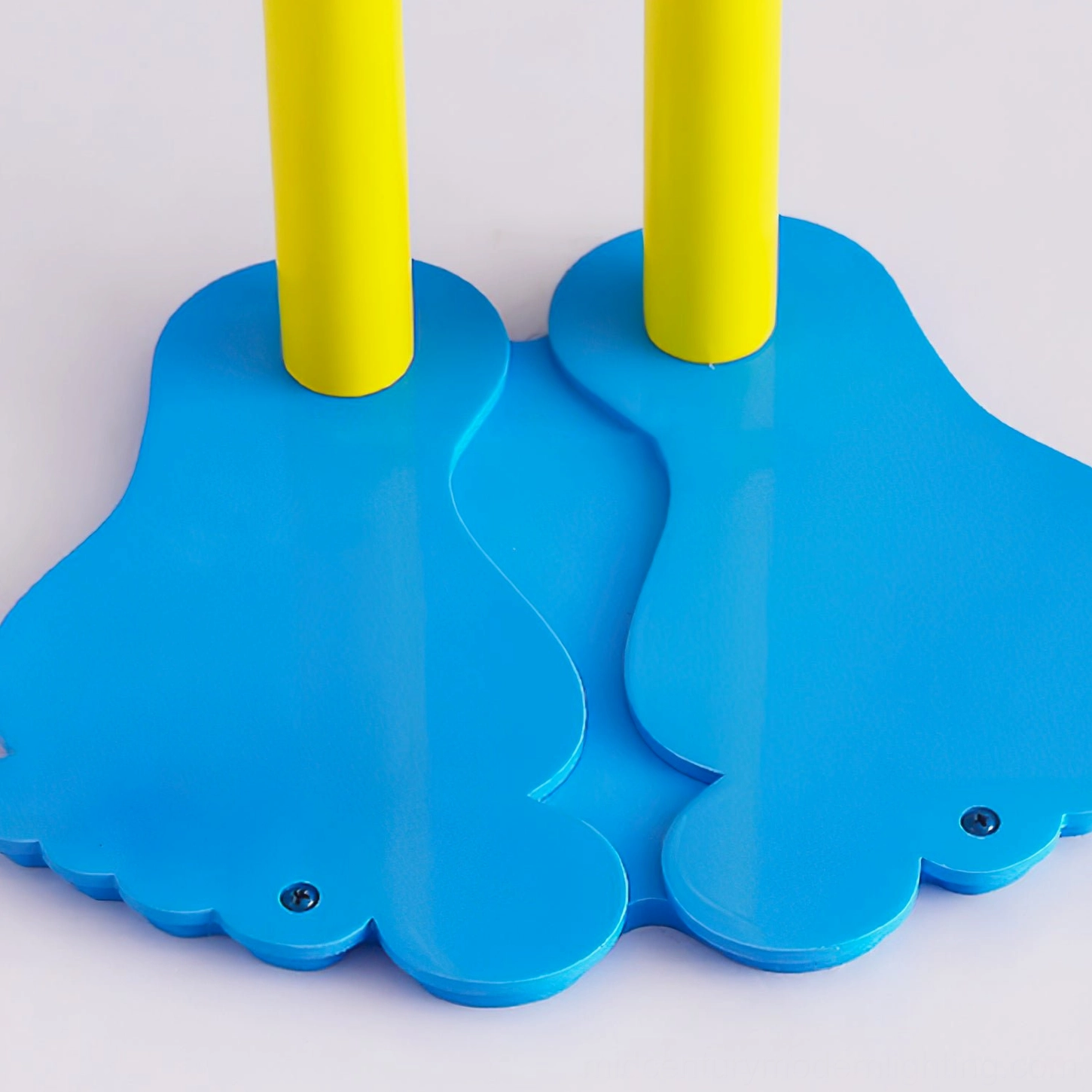Overhead view of dual barefoot-style blue metal base of smiley face lamp, architectural design detail