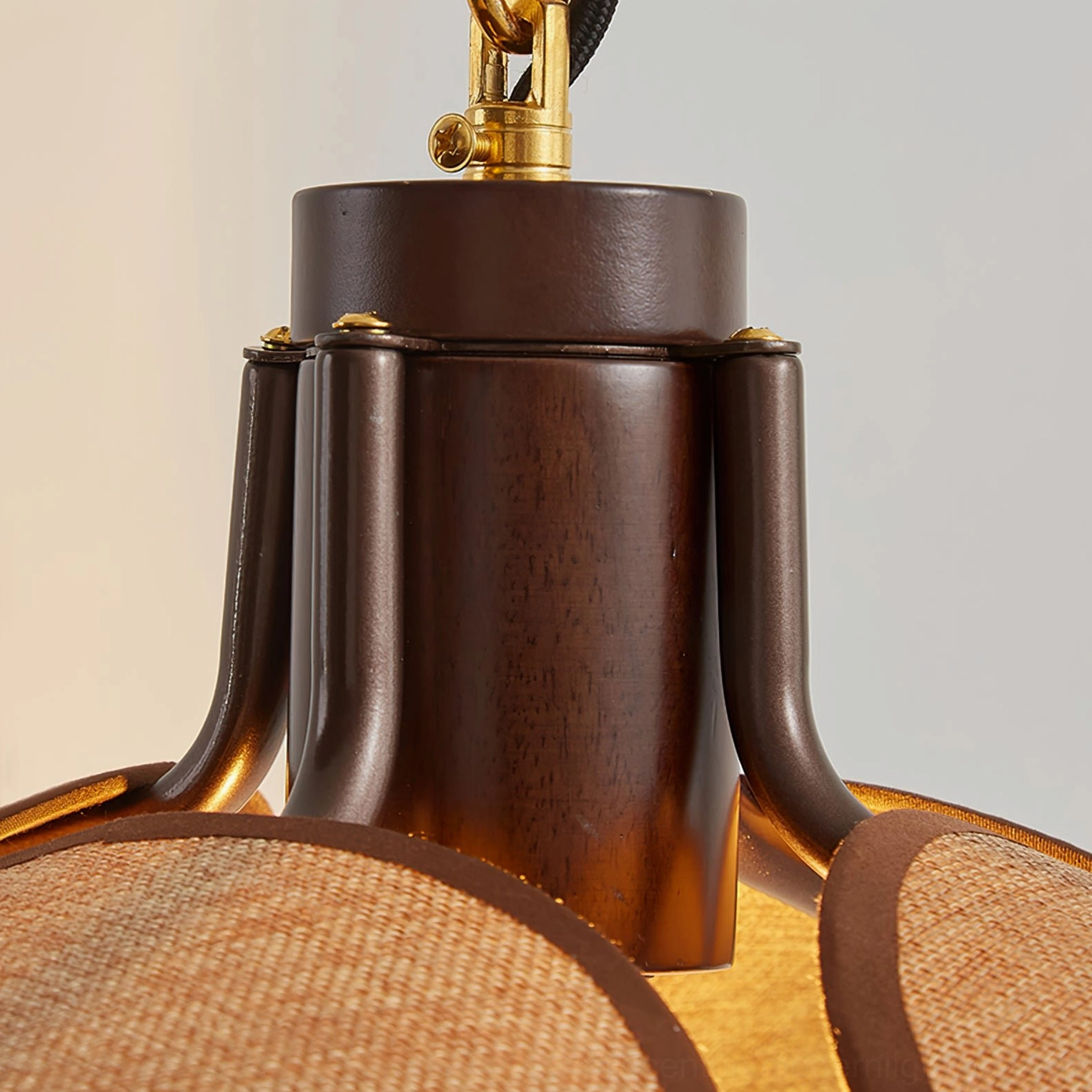 Wall lamp joint base and hardware showing brass accent accents on dark brown metal, overhead view