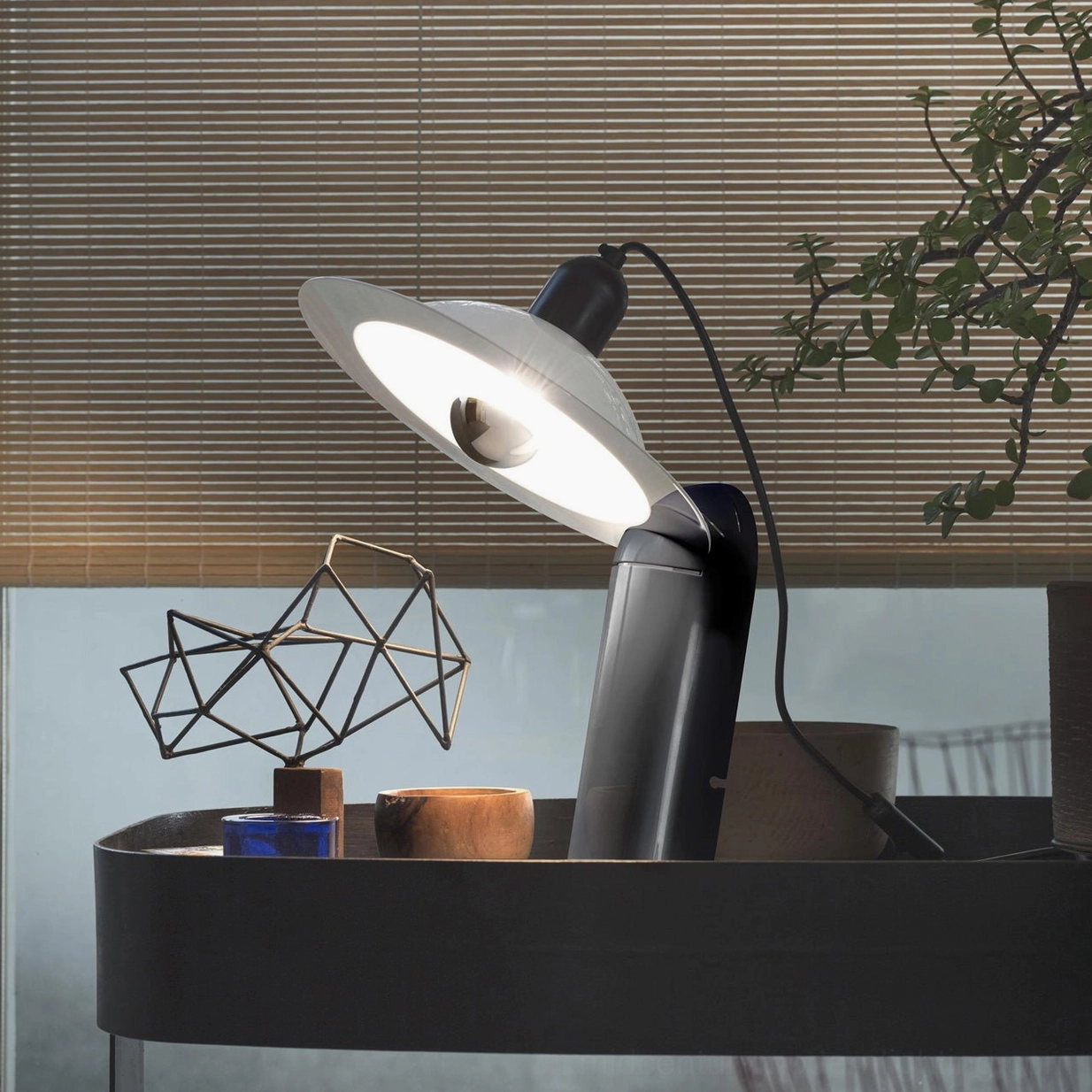 Lampiatta modern disc table lamp in minimalist home office setting on neutral desk with adjustable light direction