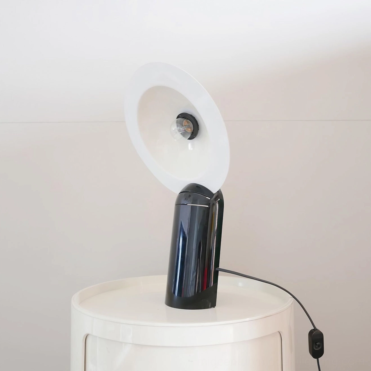 Lampiatta table lamp side view showcasing adjustment mechanism and smooth metal construction with minimalist design
