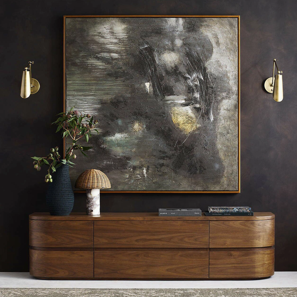 Small sculptural table lamp on dark luxury console with wall sconces and large artwork - intimate lighting
