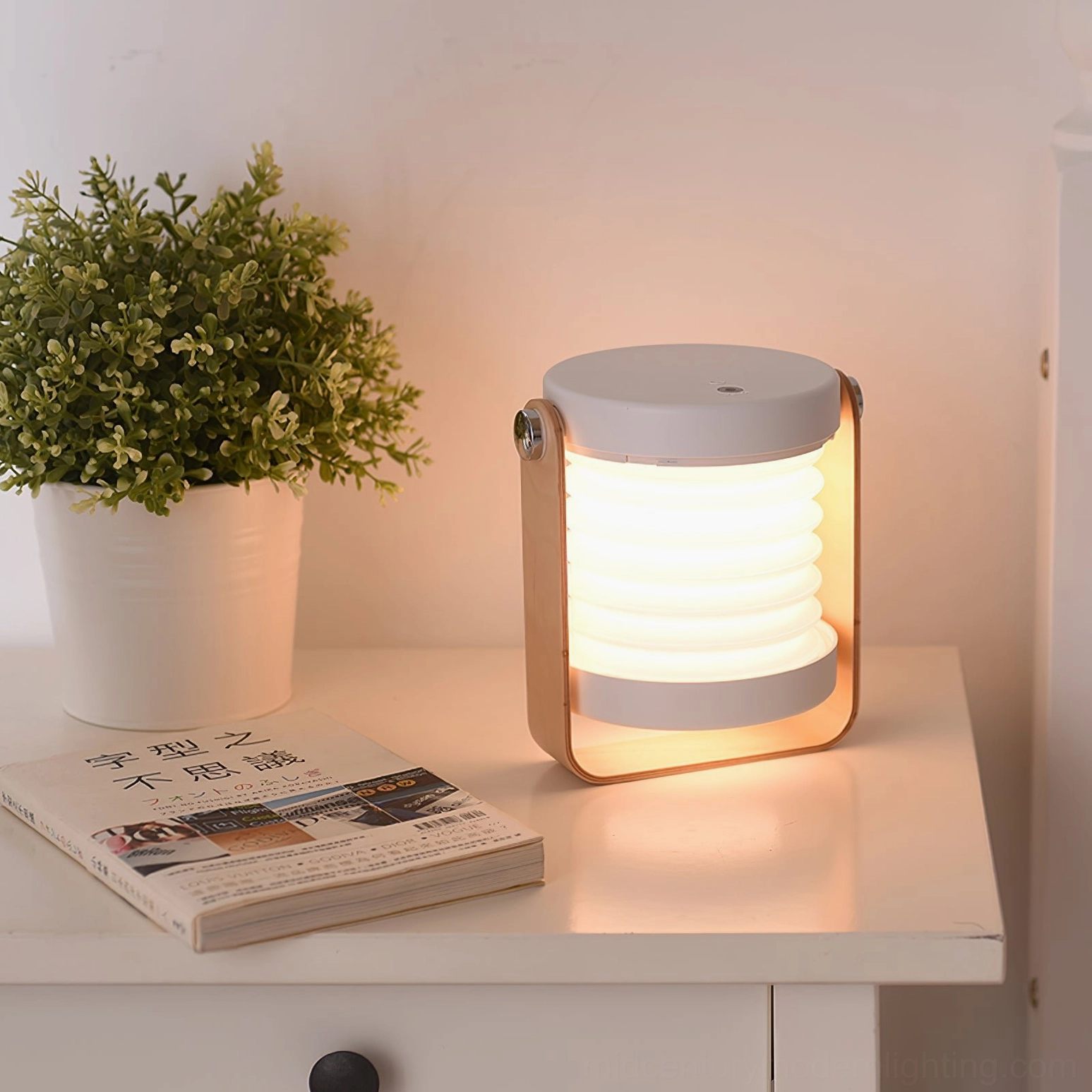 Lantern table lamp on bedroom nightstand with potted plant and books, demonstrating interior design styling for scandinavian bedroom
