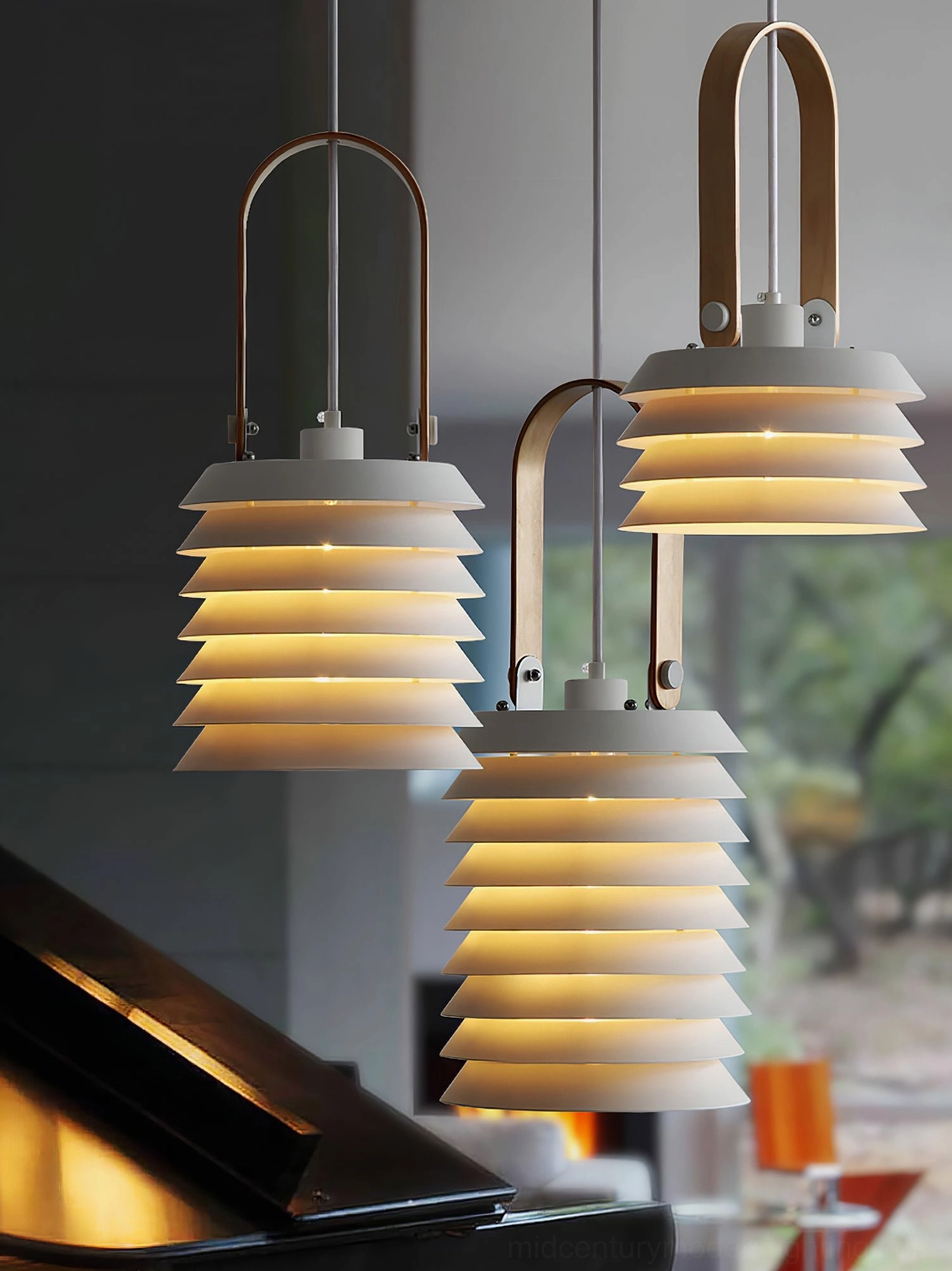 Pair of tiered lantern pendants casting warm ambient light in living room with piano
