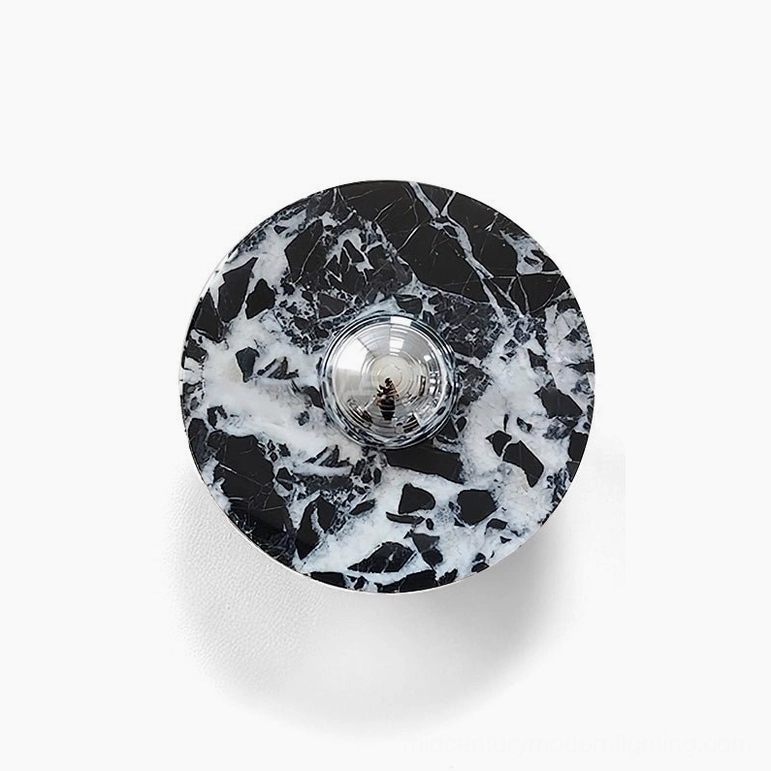 Large black marble wall lamp with chrome metalwork accent installed on beige wall showing scale and presence