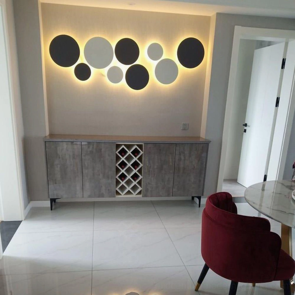 Large multi-tone geometric disc wall installation in contemporary dining entryway with mixed black and white modern design aesthetic