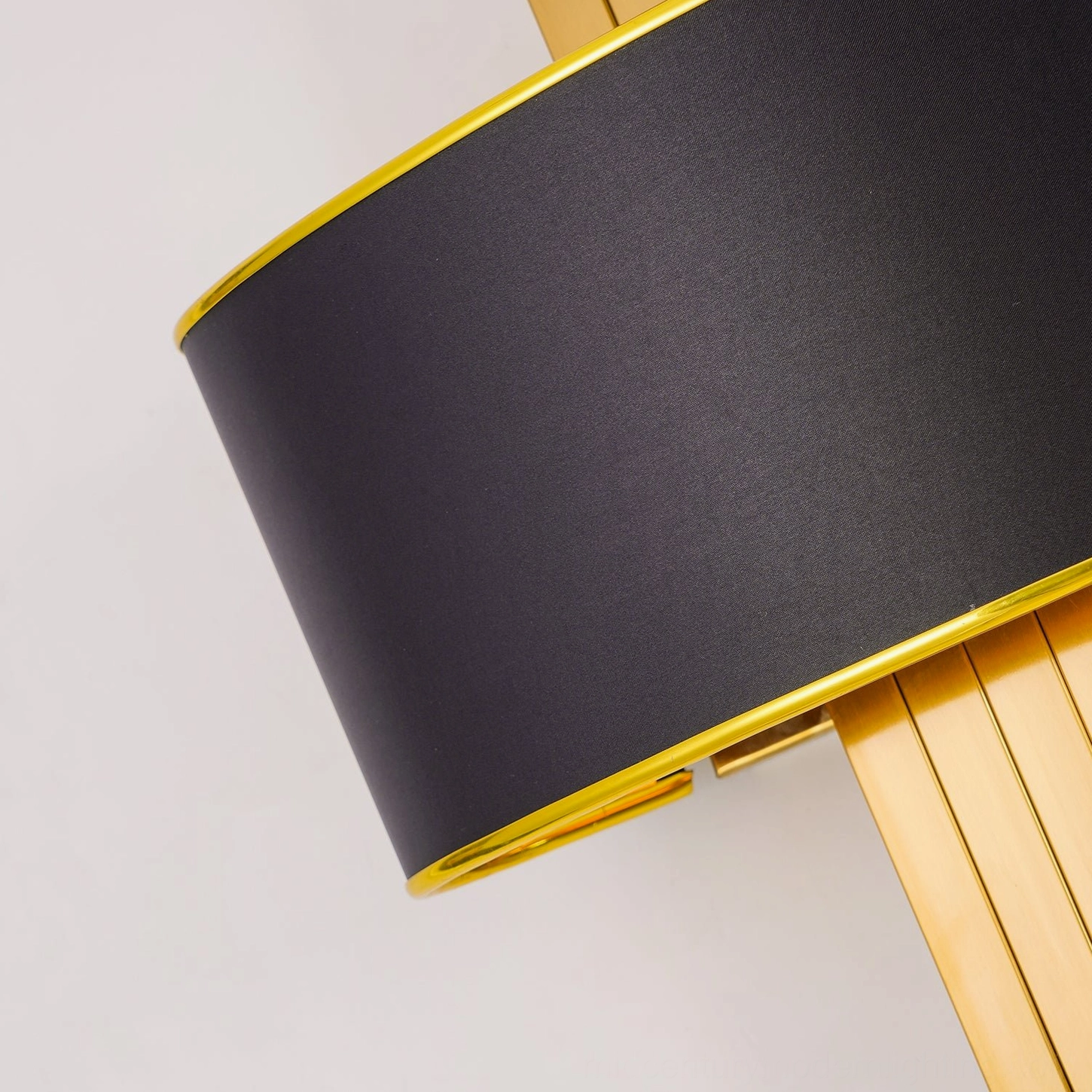 Laurina wall sconce shade detail macro shot with brushed gold metal border trim and dark fabric