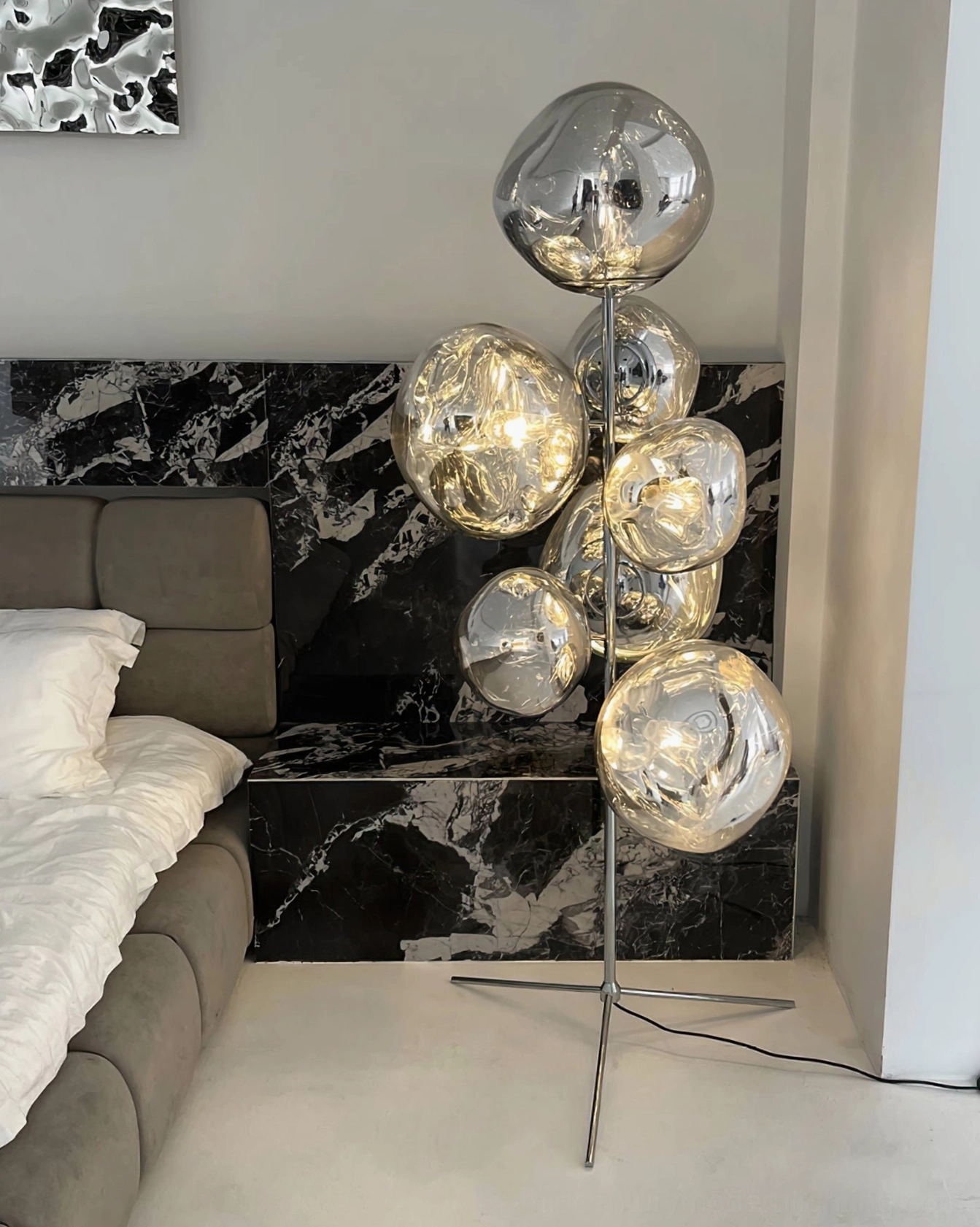 Upscale lava cone floor lamp in modern master bedroom with marble accent wall background