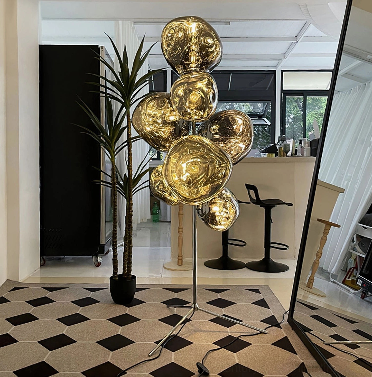 Full height view of molten glass cone floor lamp with contemporary minimalist tripod frame