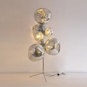 Three-quarter angle view of modern lava cone floor lamp showing molten glass texture and metallic base