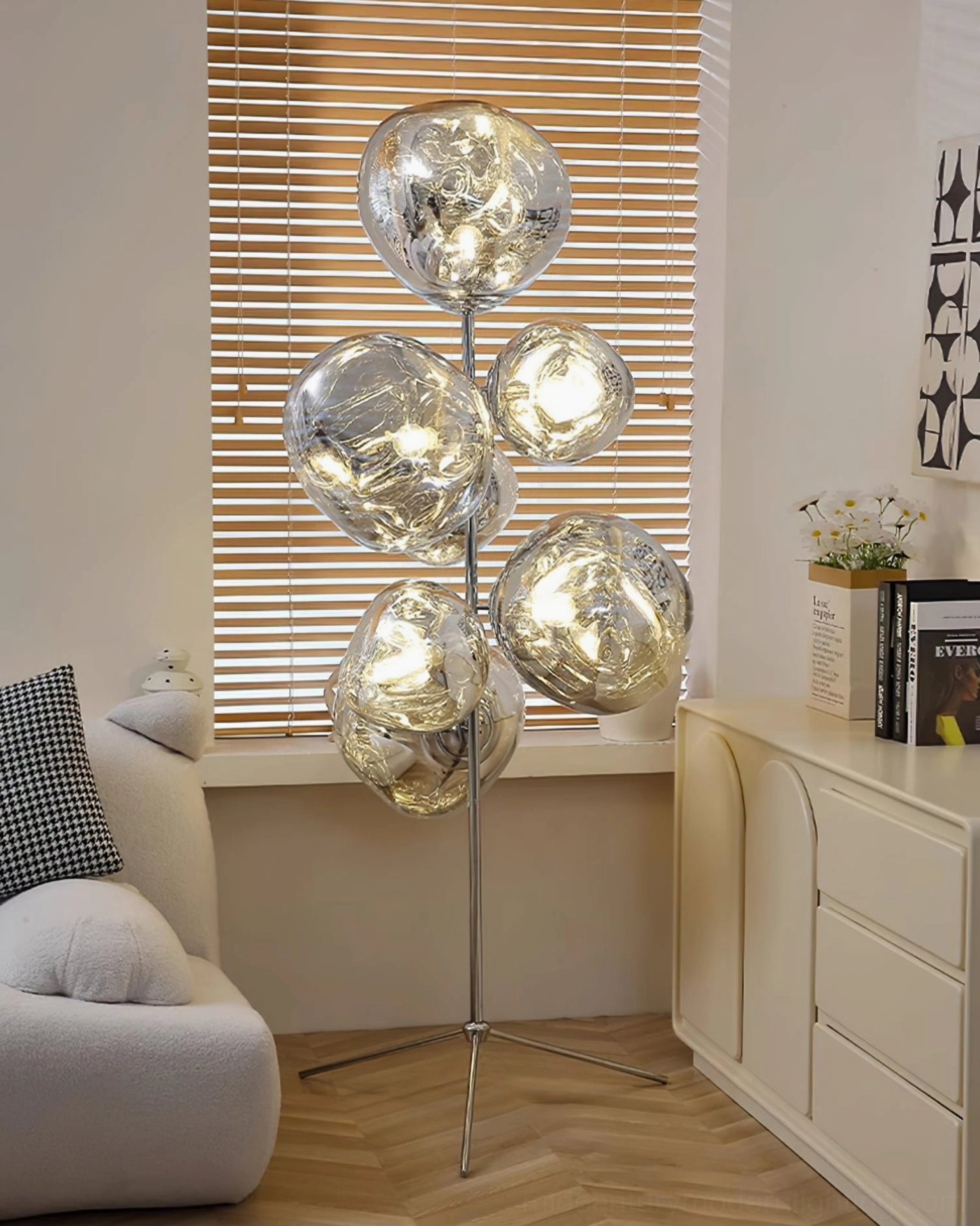 Contemporary floor lamp with silver metal base positioned in residential window nook near blinds