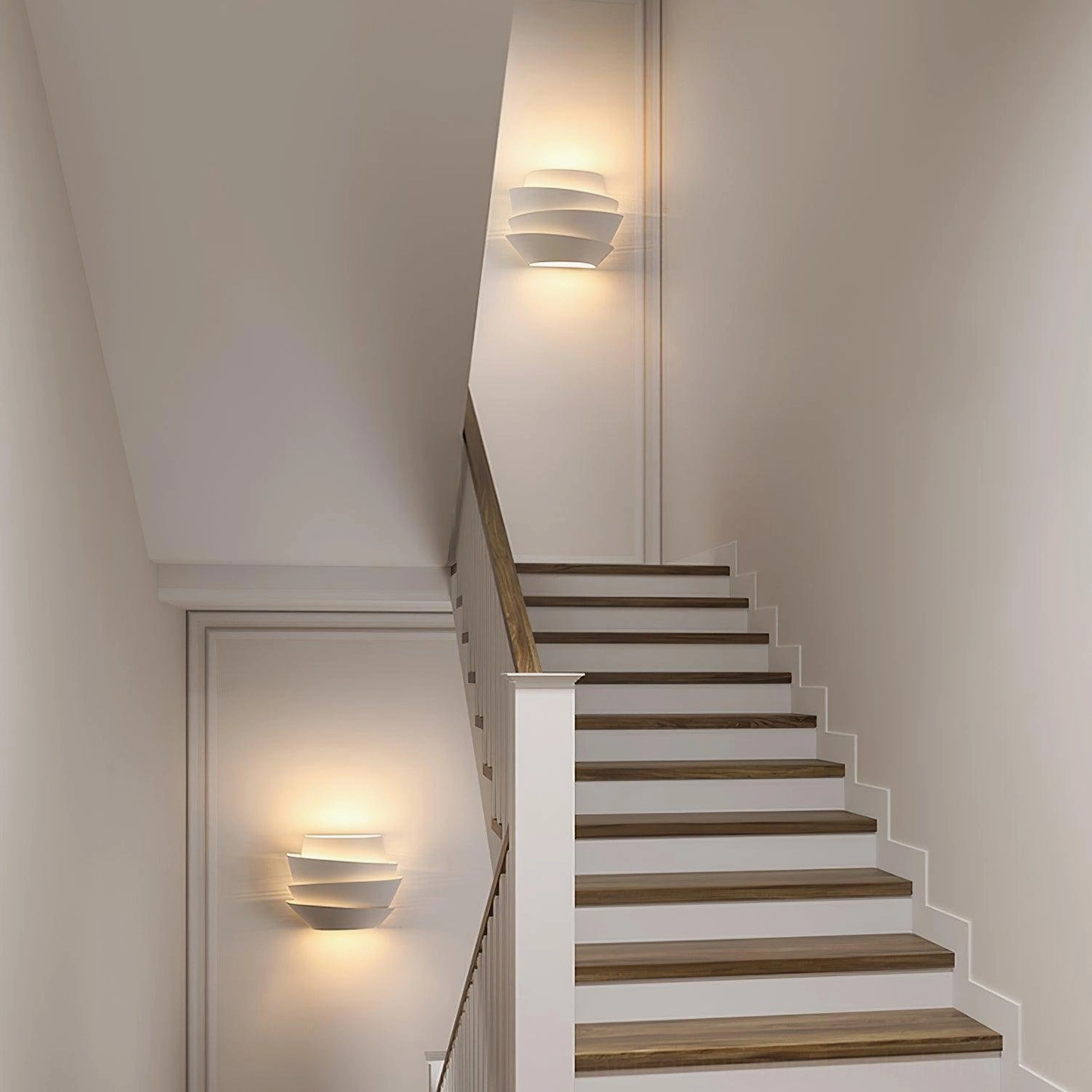 Le Soleil tiered wall sconce mounted on home stairwell wall with minimalist architectural presence