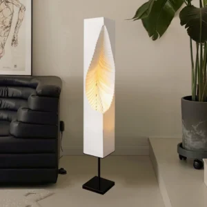 Leaf Floor Lamp in modern living room corner, three-quarter view next to leather sofa and green potted plant