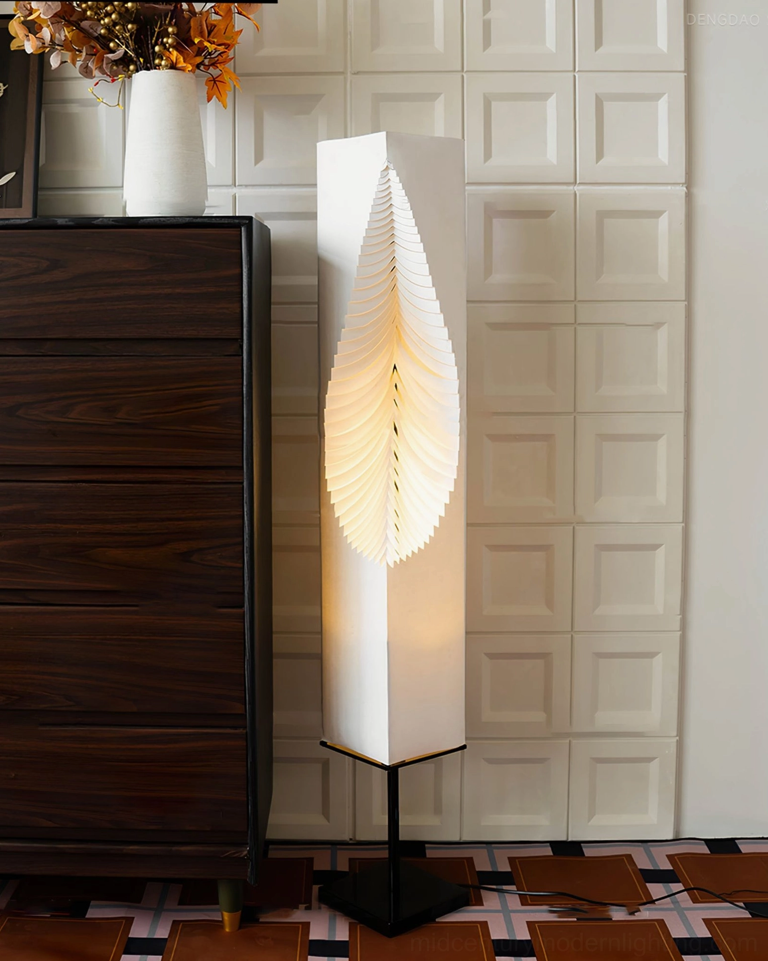 Leaf Floor Lamp side view illuminated with warm yellow glow, sleek minimalist silhouette against vintage wood cabinet
